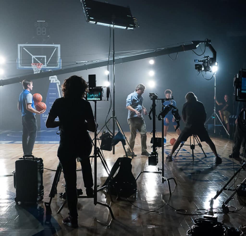 Producer Patrick Barlow on set for a video production on a basketball court at Saint Louis University.