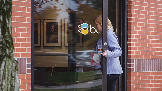 woman opening door that reads BARLOW