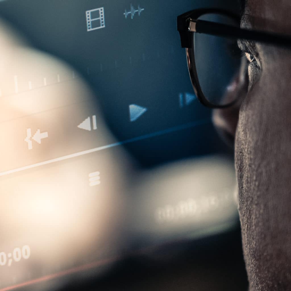 A man looks at a screen editing video