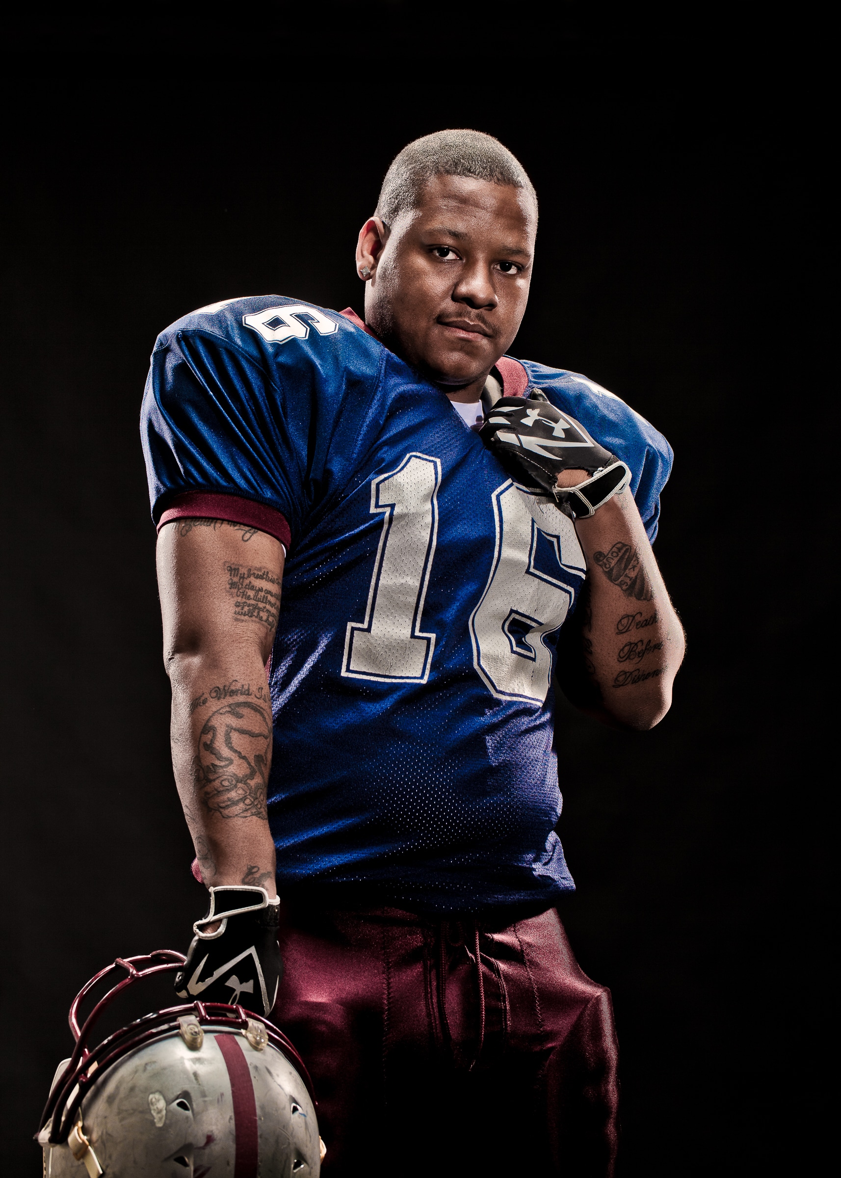 editorial portrait of football player A football player in uniform against a black studio background