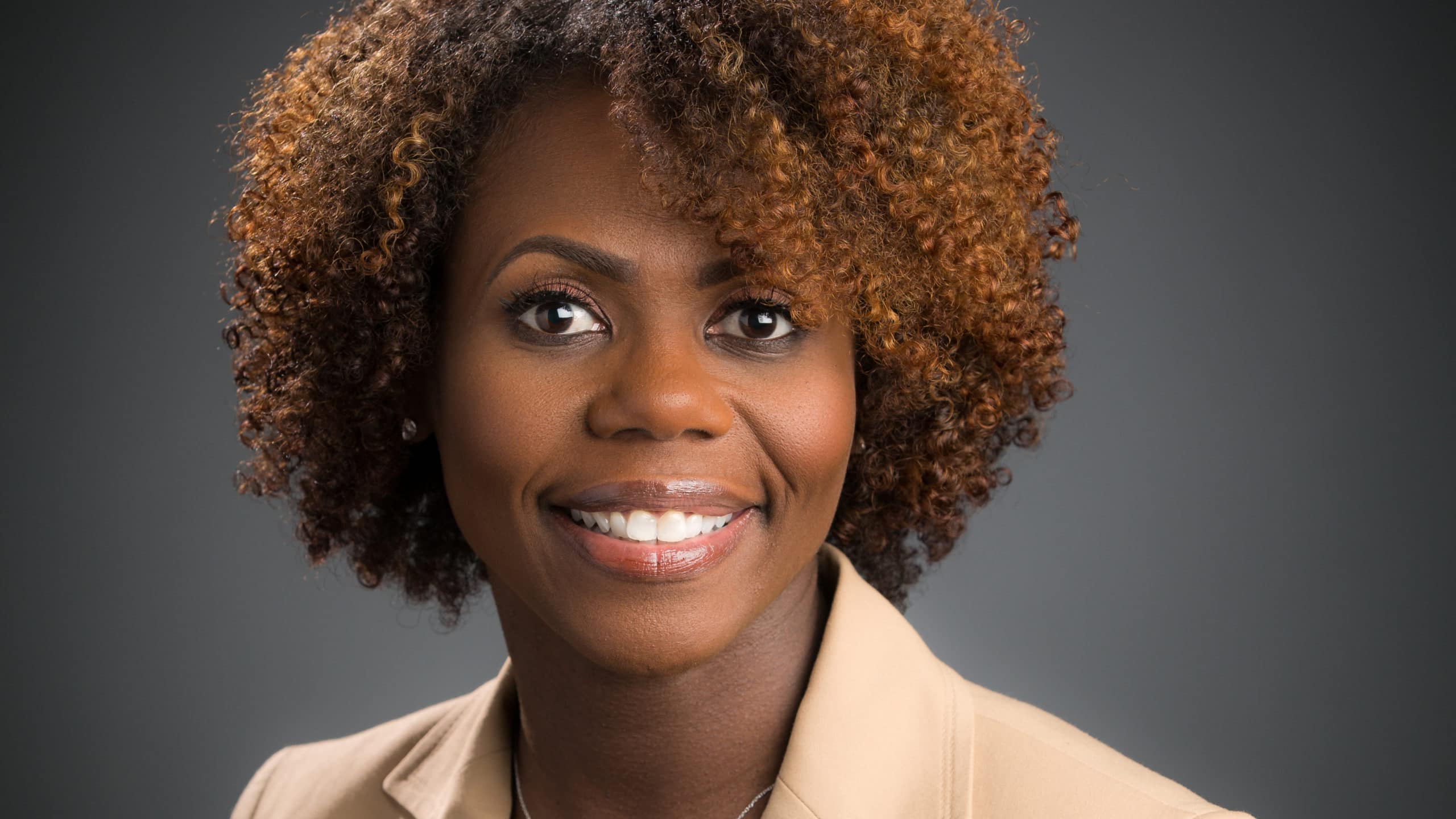 smiling woman headshot curly hair