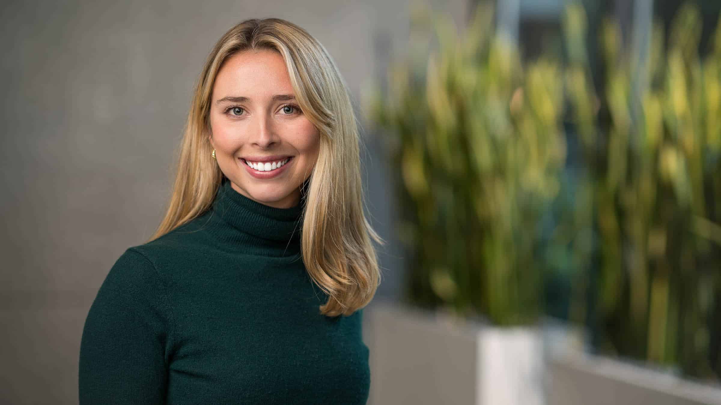 Woman in dark gray turtleneck sweater, professional headshot portrait, dressed nice