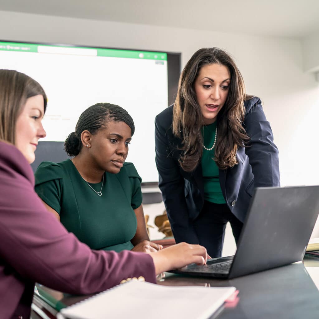 Three women work together in an office setting