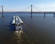 Aerial of barge in river near bridge